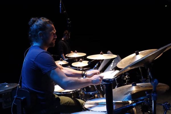 Le batteur de profil derrière ses cymbales